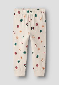 Bawełniane spodnie piżamowe z kremowym tłem, zdobione świątecznymi wzorami, takimi jak drzewa, prezenty i laseczki. Elastyczny pas.