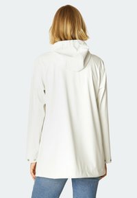 Chaqueta impermeable blanca con capucha, con un corte relajado y detalles de botones a presión en los puños. Tejido suave y ligero.