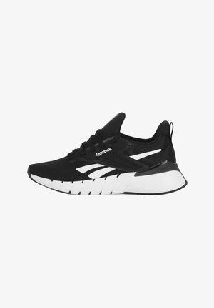 Zapatilla negra y blanca de Reebok con parte superior de malla, suela acolchada gruesa, diseño con cordones y detalles con la marca en el lateral y el talón.