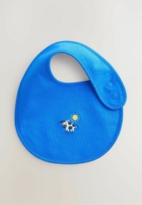 Blå bomullsficka med rund form, med broderi av en ko och en sol. Stängs med två tryckknappar upptill.