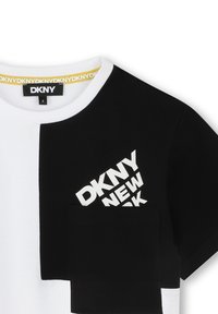 T-shirt noir et blanc DKNY avec un design coloré, col rond, grand logo et une poche avant de couleurs contrastées.