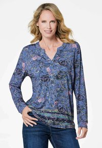 Langärmliges blaues Oberteil mit einem floralen Muster, das eine V-Ausschnitt und eine lockere Passform aufweist. Weicher Stoff mit verschiedenen grünen und pinken Akzenten.