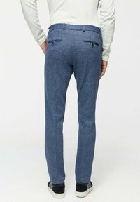 Blauwe textuurbroek van stof met een subtiel heatherpatroon. Voorzien van twee achterzakken met knoopsluitingen en een slim fit ontwerp.