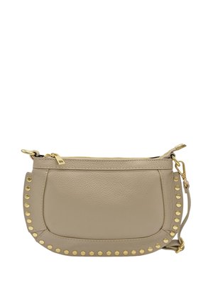 Sac bandoulière en cuir beige avec des clous dorés sur le côté, fermeture éclair sur le dessus et une bandoulière amovible. Texture lisse et forme arrondie.