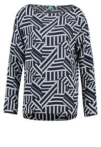 Marinblå långärmad topp med ett geometriskt mönster av växelvis vita ränder och enfärgade paneler, med en avslappnad passform och vid halsringning.