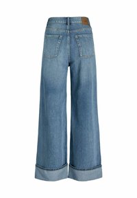 Jeans de pierna ancha en denim azul claro, con dobladillo remangado, cinco bolsillos y una etiqueta de cuero marrón en la parte trasera.