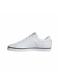 Zapatillas bajas blancas hechas de material sintético, con una superficie lisa, suela plana, seis ojetes y un acento negro en la suela de goma.