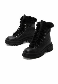 Botas de combate negras con parte superior de cuero texturizado, cuello de pelaje sintético, ojales plateados y suela de goma gruesa para tracción.