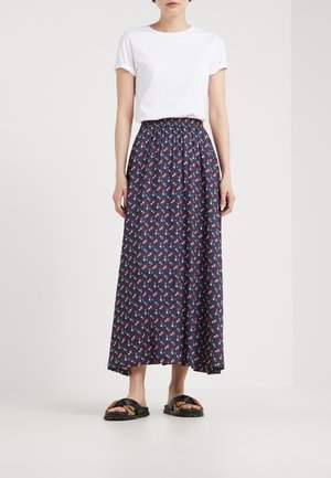 Falda azul marino con estampados florales en rojo y blanco, cinturilla elástica, combinada con una camiseta blanca de manga remangada y sandalias negras.