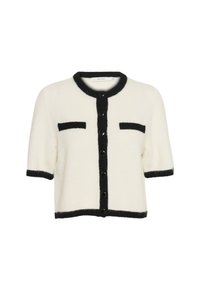 Short-sleeved cardigan, cream with black trim, featuring button closure and two front pockets. Soft texture and boxy shape.