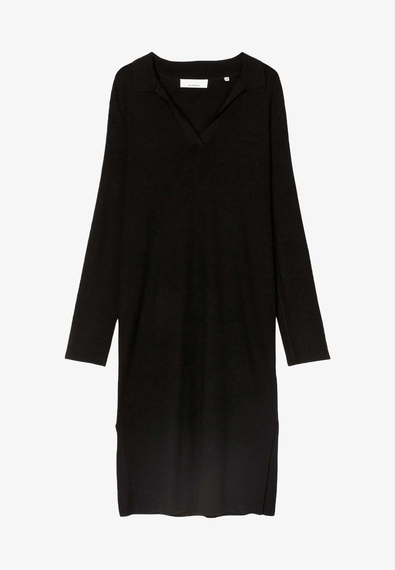Robe noire à manches longues en tricot côtelé avec col en V et fentes latérales, longueur genou, silhouette simple et ajustée.