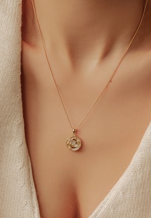 Goldene Halskette mit einem runden Anhänger in gedrehter Gestaltung, ergänzt durch eine zarte Kette. Der Anhänger ist mit einem strukturierten Rand akzentuiert.