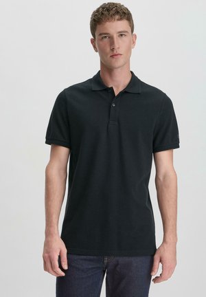Zwarte polo shirt van gestructureerde katoen. Korte mouwen, placket met twee knopen en subtiele logo-detail op de mouw. Aansluitend ontwerp.