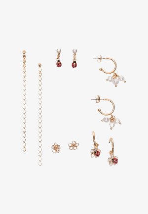 Six paires de boucles d'oreilles en ton or, comprenant une chaîne longue, une coccinelle avec perle, des créoles avec un regroupement de perles, de petites fleurs blanches, et une fleur avec des breloques coccinelle.
