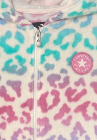 Polarowa bluza z kapturem na zamek, w różowo-niebiesko-fioletowy wzór w panterkę. Posiada okrągłe różowe logo "Converse All Star" na klatce piersiowej.