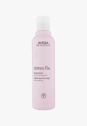 Bottiglia di lozione per il corpo rosa chiaro con tappo a scatto. L'etichetta mostra "stress-fix" e il marchio. Texture liscia, forma ovale, design minimalista.