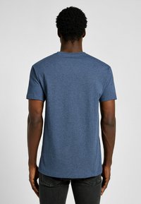 Blauwe koker met korte mouwen van een katoenmix met een textuurafwerking. Klassieke ronde hals en een rechte zoom.