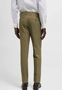 Olive green tailored trousers with a slim fit, featuring back pockets with buttons and a smooth fabric texture. There are crease lines down the front.