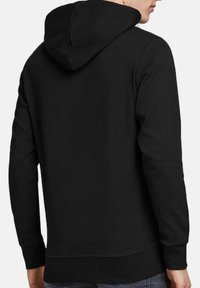 Sweatshirt noir avec capuche, manches longues et ourlet côtelé. Texture de tissu lisse, design minimaliste, sans motifs ni ornements visibles.