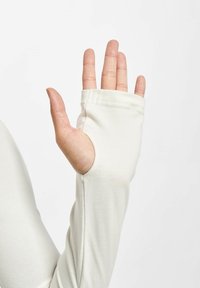 Ľahký top s dlhým rukávom v off-white farbe s výrezom na palec a mäkkou textúrou. Má minimálne švy pre hladké prevedenie.