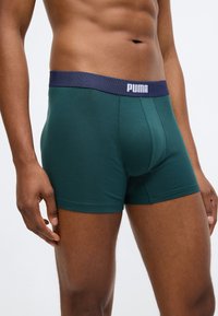 Πράσινες βαμβακερές BOXER σορτς με ναυτική ελαστική μέση που φέρει το λογότυπο "PUMA". Στενή εφαρμογή με λείο υφή και χωρίς ορατά σχέδια.