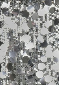 Tessuto in paillettes argentate con forme circolari e rotonde, caratterizzato da una combinazione di finiture lucide e opache, sovrapposto a uno sfondo testurizzato.