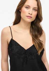Črna satenasta majica s čipkastim prekrivom na izrezu, z nastavljivimi tankimi naramnicami in izrezom v obliki črke V. Gladek tekstura.
