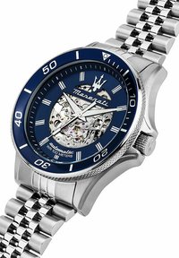 Stainless steel automatic watch with a blue dial, transparent casing, and silver-tone bracelet. Features white hour markers and water resistance.
