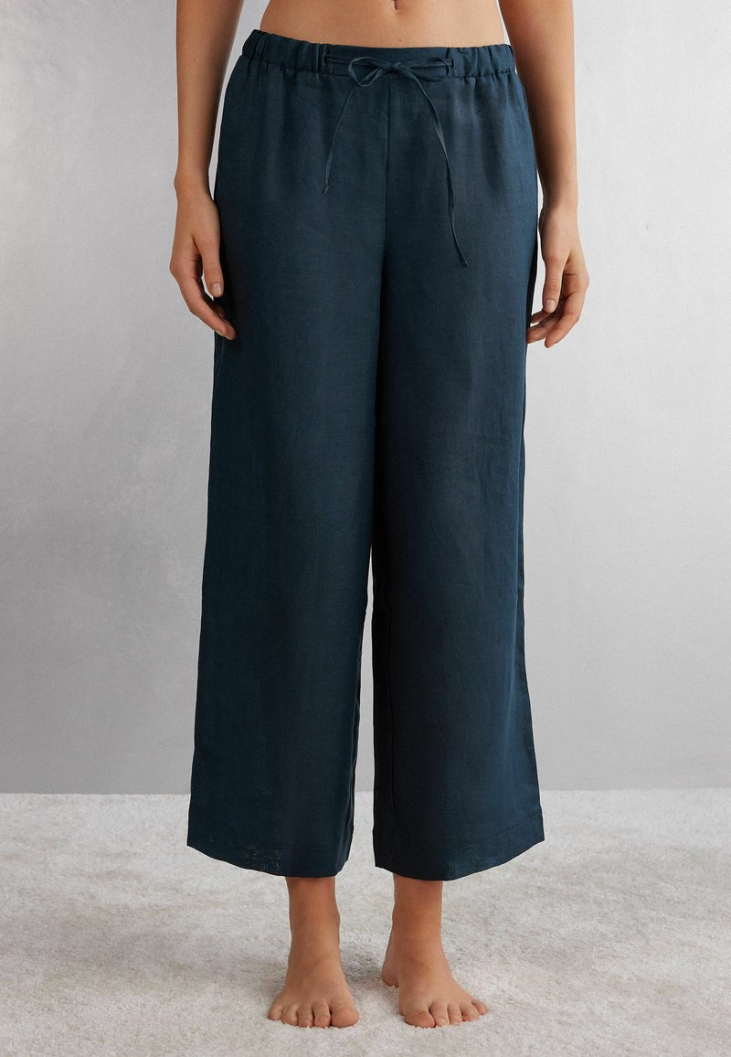 Pantalones de lino de pierna ancha en azul marino oscuro, con una cintura elástica fruncida y cordón, textura suave y un ajuste relajado.