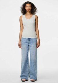 Hellgraues Tanktop mit rundem Halsausschnitt, aus weichem Stoff, kombiniert mit weit geschnittenen blauen Jeans aus Denim mit einer verwaschenen Textur.