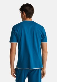 Modré bavlněné tričko s krátkými rukávy, se kontrastním šedým lemem kolem límce a rukávů, hladká textura, jednoduchý design.