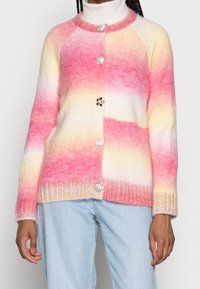Il cardigan lavorato a maglia presenta un motivo sfumato in rosa, giallo e bianco. Ha un orlo a costine e decorativi bottoni in rilievo.