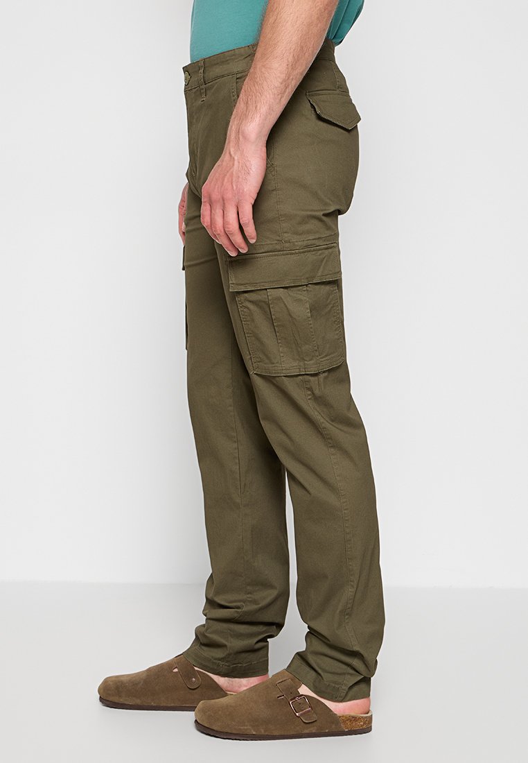 Zielone oliwkowe spodnie cargo o luźnym kroju, wykonane z bawełnianego materiału. Posiadają cztery duże kieszenie oraz widoczne detale szycia.