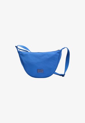 Sac bandoulière bleu en forme de croissant avec une sangle ajustable et une fermeture éclair, présentant un petit patch de marque rectangulaire à l'avant.