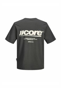 Grafitszürke pamut rövid ujjú póló. Nagy fehér szövegnyomat a hátoldalon, „jjcore” felirattal és további márkajelzésekkel.