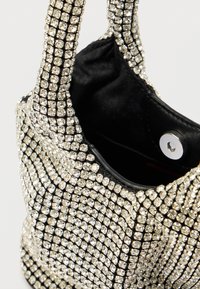 Μαύρο τσάντα με στρας και δύο λουριά, με λείο εσωτερικό και κούμπωμα με πάτημα. Λαμπερά κρυσταλλένια διακοσμητικά στο εξωτερικό.