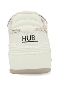 Witte sneaker met gestructureerde beige accenten, gewatteerde kraag en een dikke rubberen zool. Bevat het "HUB"-logo op de hiel. Glad en strak ontwerp.