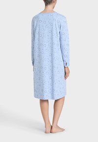 Camice da notte in cotone azzurro chiaro con maniche lunghe, motivo floreale, scollatura rotonda e lunghezza al ginocchio. Presenta polsini con bottoni e spacco laterale.
