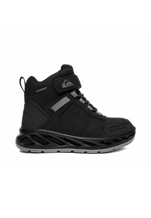 Zapatilla negra impermeable de caña alta con cierre de velcro, detalles reflectantes, suela acolchada y lengüeta trasera.