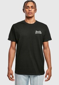 Zwarte katoenen t-shirt met korte mouwen, met witte tekst "Honestly Nevermind" op de linkerborst. Klassieke ronde halslijn.