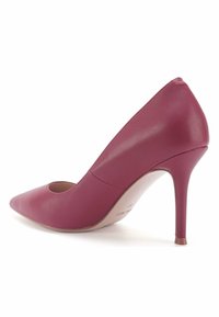 Scarpa con tacco alto in pelle bordeaux, punta affusolata, texture liscia e design con ritagli sui lati. Il tacco a stiletto conferisce altezza.