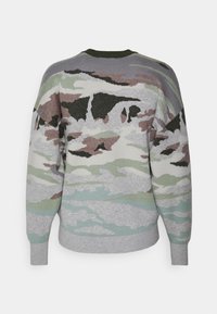Jersey de punto con un patrón de camuflaje en gris, verde y rosa. Presenta un cuello y dobladillo acanalados, con un ajuste relajado y una textura suave.