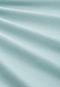 Soft light blue fabric with subtle folds and a smooth texture.