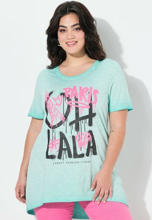 T-shirt verde menta con scollo rotondo, maniche corte e un orlo posteriore più lungo. Presenta grafiche audaci in nero e rosa.