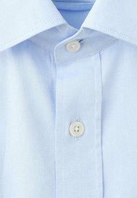 Svetlo modra teksturirana srajca s klasičnim ovratnikom in enim belim gumbom na zapenjalnem traku. Tkanina je tkana z nežnim vzorcem.