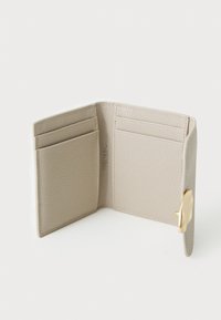 Světle šedá kožená peněženka, jemně texturovaná, s více sloty na karty a akcentem zlatého kovu na straně. Úzký, elegantní design.
