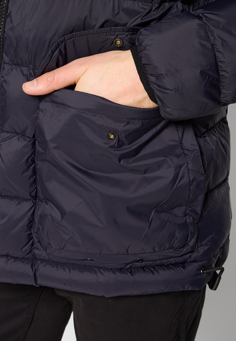 Donkerblauwe gewatteerde jas met een rits aan de voorkant, voorzien van een zijzak met drukknopsluiting en elastische boorden voor een stevige pasvorm.