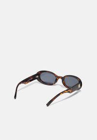 Round sunglasses with a tortoiseshell acetate frame, grey lenses, and thin arms featuring gold accents. Texture appears smooth and polished.