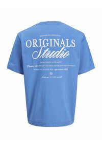 Blauwe katoenen t-shirt met korte mouwen. Tekst op de achterkant in het wit leest "ORIGINALS Studio" en details over ontwerp en locatie.