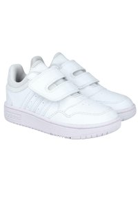 Baskets blanches avec des sangles Velcro, en matériau synthétique lisse, avec un design perforé sur les côtés, un bout rond et des semelles en caoutchouc.